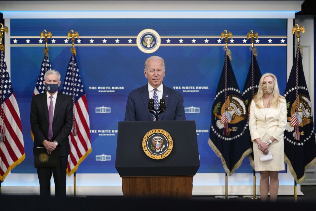 President Biden at a lectern, flanked by Jerome Powell and Lael Brainard.
