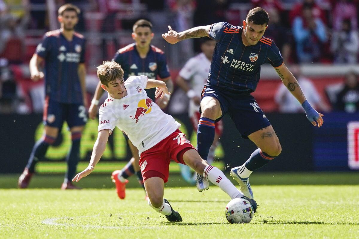 FC Cincinnati's Brandon Vázquez tries to keep control of the ball as New York Red Bulls midfielder Daniel Edelman slides in.