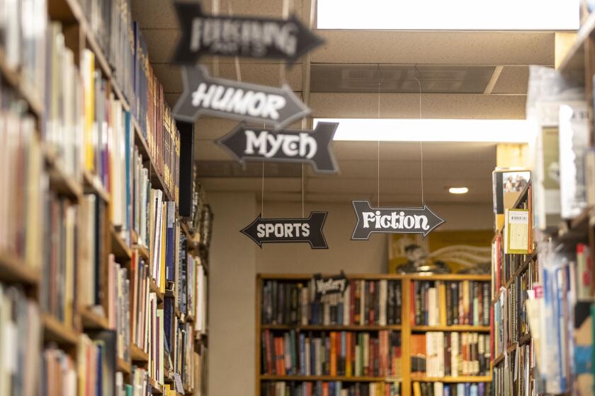 San Diego, CA - November 18: Arrows point to indicate where each genre of book is located inside La Playa Books on Friday, Nov. 18, 2022 in San Diego, CA. (Meg McLaughlin / The San Diego Union-Tribune)