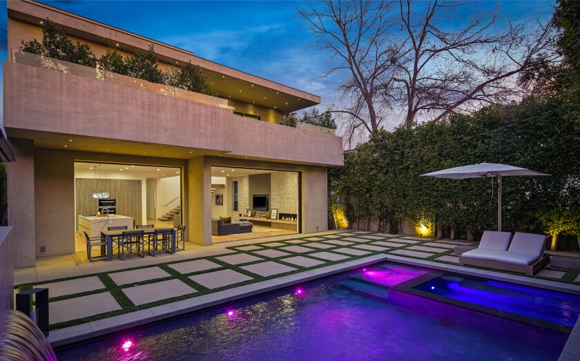 A view of the backyard with a swimming pool and spa.