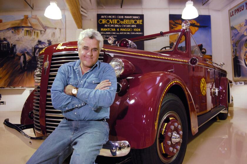 Jay Leno, former host of "The Tonight Show with Jay Leno" and current host of the car-centric TV show "Jay Leno's Garage," poses against an antique fire truck at his private garage of classic cars in Burbank, Calif., in May 2007.
