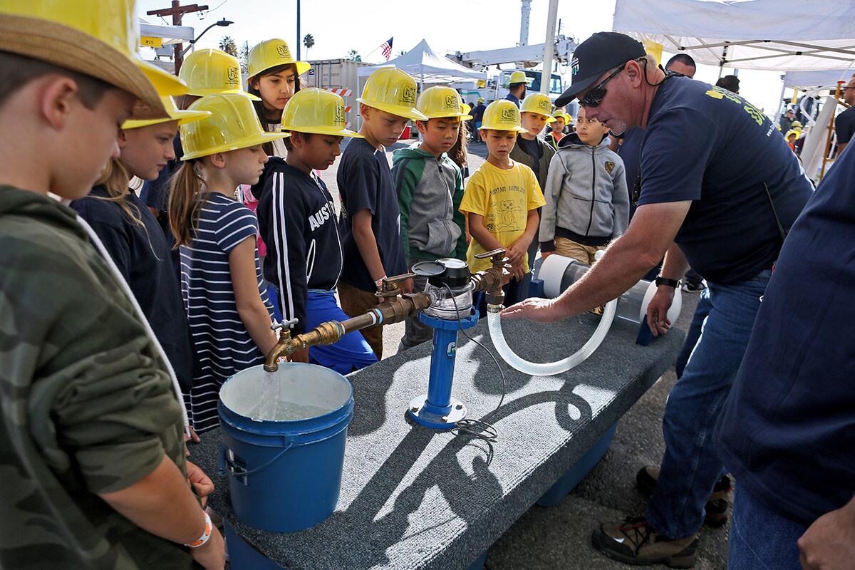 Senior water system mechanic Albert Luquin, right, shows Mountain Avenue Elementary School students how water is delivered to homes at the Water Meter Repair Station during annual Glendale Water and Power Utility Day, at the Utility Operations Center in Glendale on Thursday, Oct. 11, 2018.