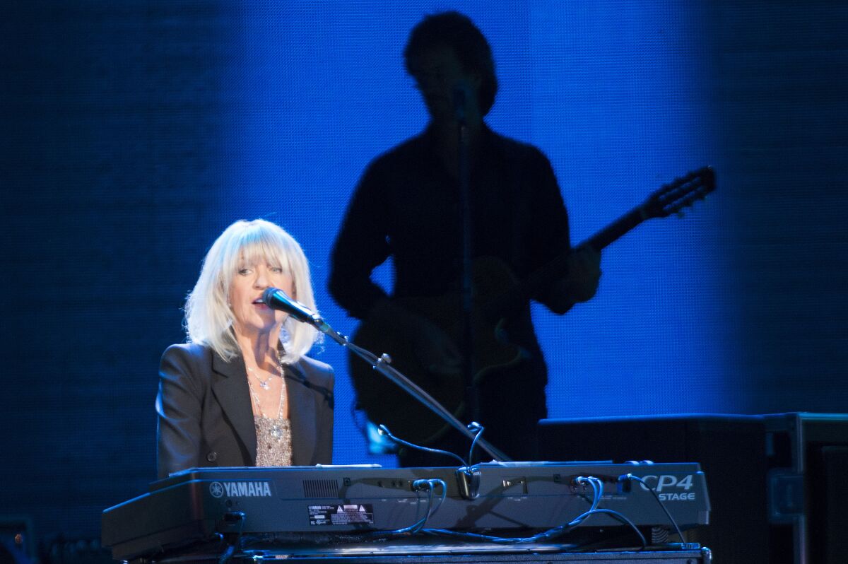 A woman sings and plays piano onstage