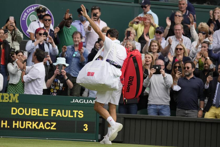 Switzerland's Roger Federer leaves the court after being defeated by Poland's Hubert Hurkacz during the men's singles quarterfinals match on day nine of the Wimbledon Tennis Championships in London, Wednesday, July 7, 2021. (AP Photo/Kirsty Wigglesworth)
