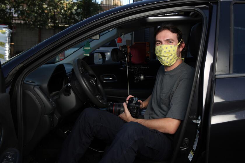 LOS ANGELES, CA - JULY 22: Ian Byers-Gamer poses for a portrait with his large format camera in view in North Hollywood on Wednesday, July 22, 2020 in Los Angeles, CA. During the pandemic the photographer has been using a large format camera to make portraits of local Los Angeles artists from the front seat of his car. (Dania Maxwell / Los Angeles Times)