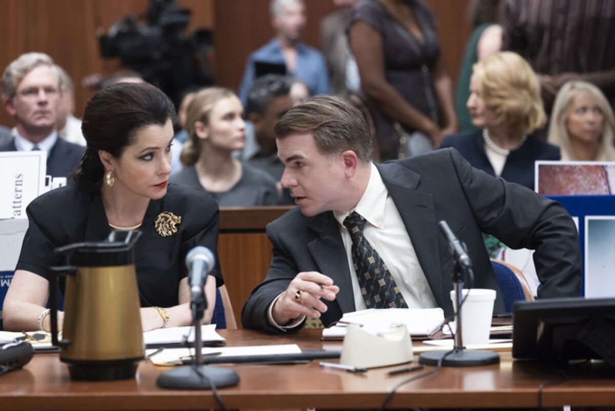 Two attorneys confer in a courtroom