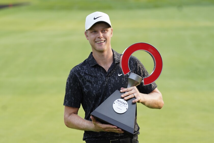 Cam Davis holds the winner's trophy after claiming victory at the Rocket Mortgage Classic.