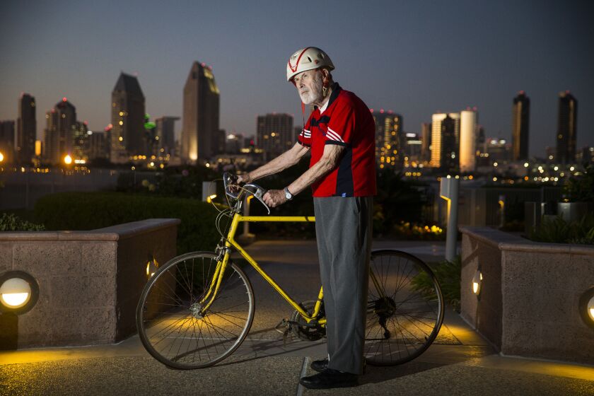 Former senator James Mills, 89, stands with the bike he rode from Sacramento to San Diego in 1972 to promote Prop 20, which created the Coastal Commission and led to the Coastal Act. The photo was taken overlooking the San Diego skyline from Mills' Coronado apartment Wednesday. (Allen J. Schaben / Los Angeles Times)
