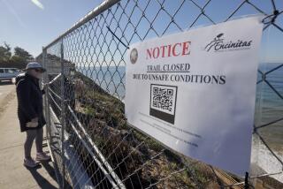 ENCINITAS, CA - JANUARY 12, 2024: Signs are posted on fencing that has been put up at the edge of the Beacons Beach parking lot to prevent people from accessing the Beacons Beach trail, which has been damaged from a landslide, in Encinitas on Friday, January 12, 2024.
