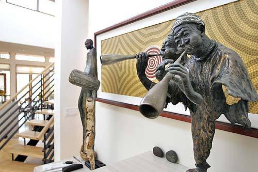 Pipers by Ed Dwight hail in front of a dotted abstract by Aboriginal artist Colin Byrd.