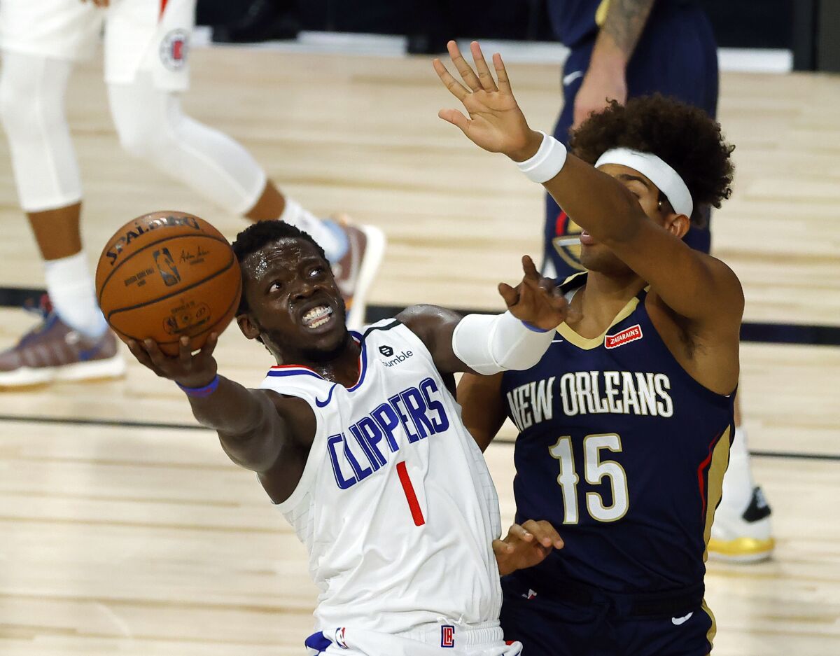Los Angeles Clippers' Reggie Jackson (1) shoots against New Orleans Pelicans' Frank Jackson (15) during an NBA basketball game Saturday, Aug. 1, 2020, in Lake Buena Vista, Fla. (Kevin C. Cox/Pool Photo via AP)