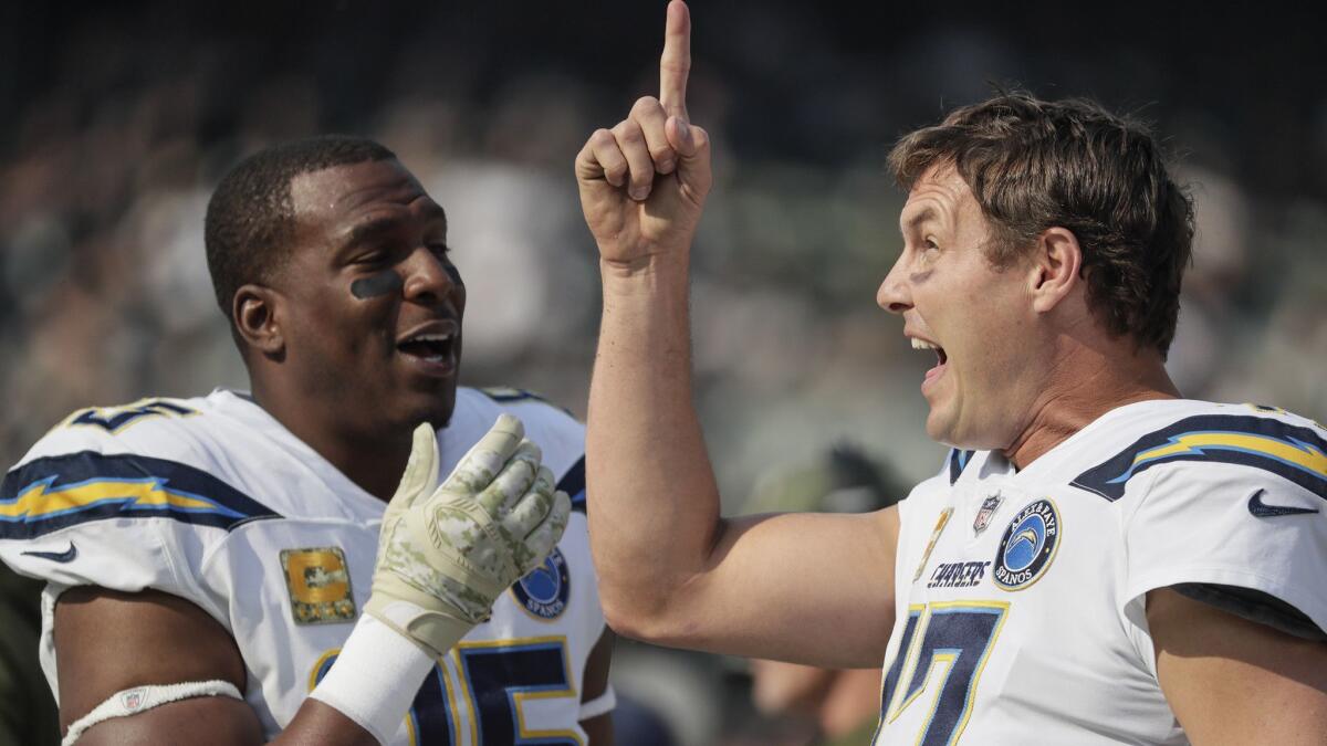 Tight end Antonio Gates, left, sharing a chuckle with quarterback Philip Rivers after averting an interception on a tipped ball against Oakland in November, is headed to the playoffs with the Chargers after re-signing with the team only a week before the opener.