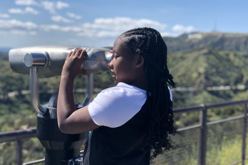 Avery Jenkins, 9, of Atlanta peers through a scope at Griffith Park Observatory during her family's visit to Los Angeles. 