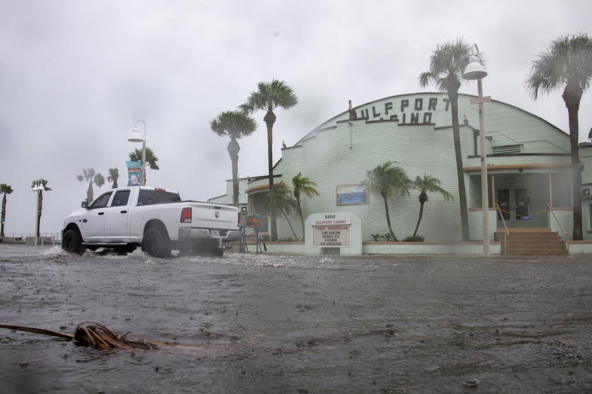 Una camioneta avanza en una calle inundada mientras el huracán Debby