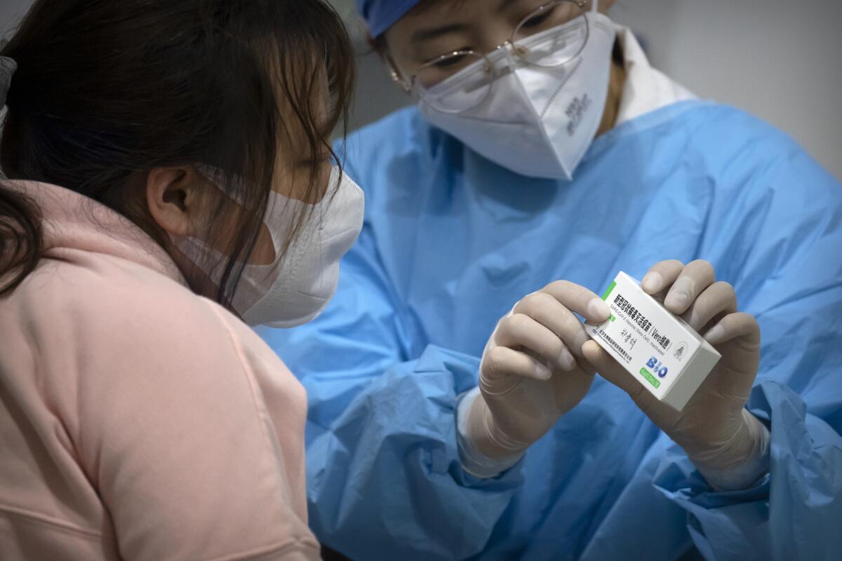 A medical worker holds a package of Sinopharm vaccine in Beijing.