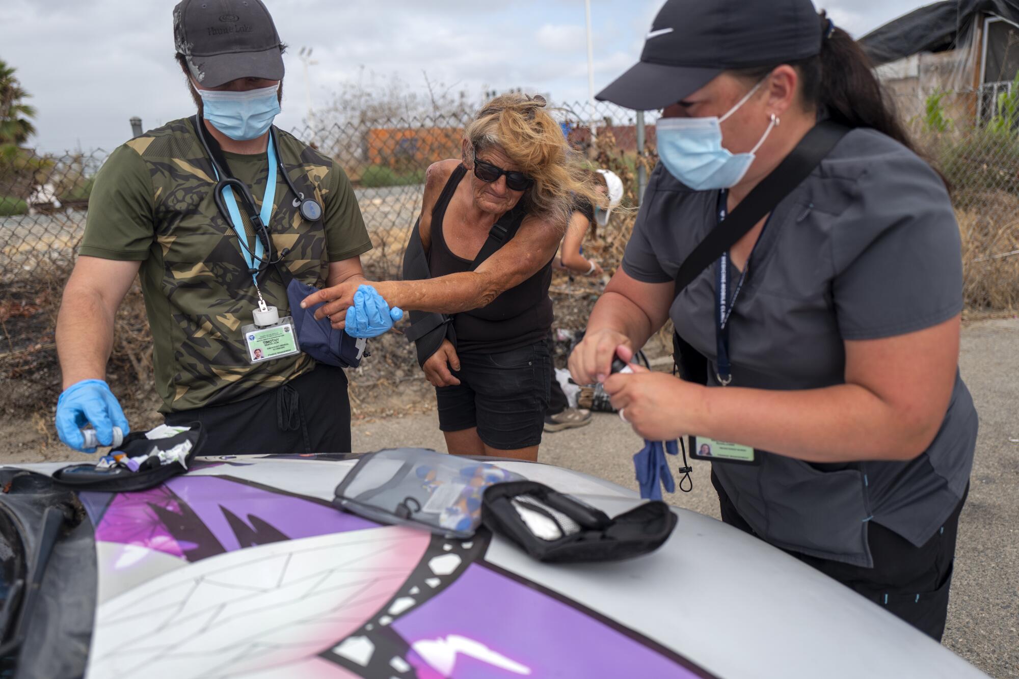 A man pricks the finger of a woman to check her blood sugar.