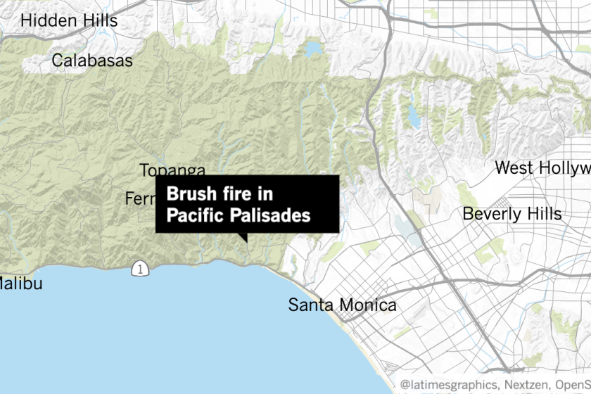 Firefighters were battling a fast-moving brush fire that has grown to 30 acres and was threatening homes in Pacific Palisades, officials said.