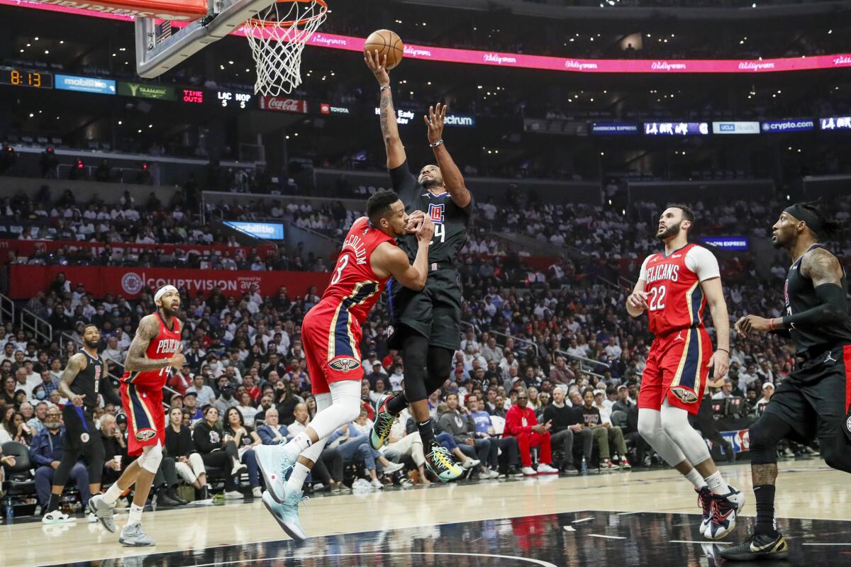 Clippers guard Norman Powell elevates above Pelicans guard C.J McCollum for a layup.