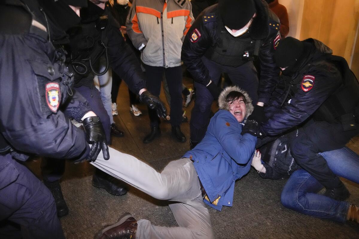 Police officers detain protesters in St. Petersburg, Russia.
