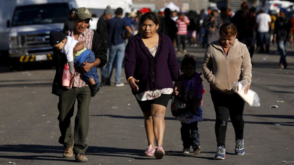 A Honduran family walks near the Benito Juarez Sports Center one block from the border in Tijuana on Nov. 26.