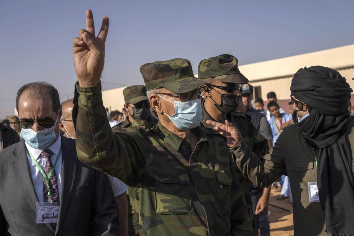 Brahim Ghali, head of the Polisario Front and the self-declared Sahrawi Democratic Arab Republic, gestures the victory sign during a National Unity Day event in the Dajla refugee camp, Algiers, Tuesday, Oct. 12, 2021. (AP Photo/Bernat Armangue)