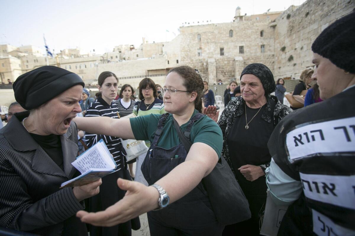 A member of the Women of the Wall organization attempts to hug an ultra-Orthodox protester Sunday at the Western Wall in Jerusalem.