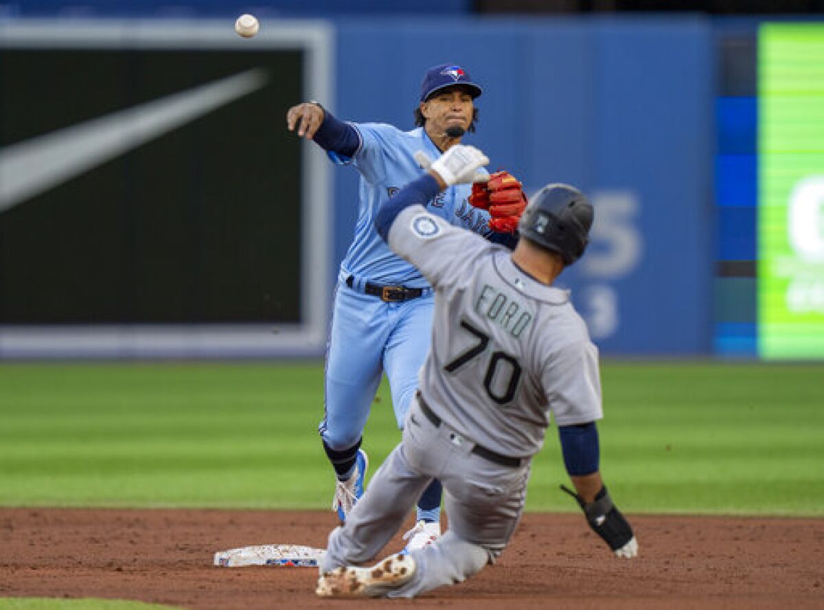Toronto Blue Jays second baseman Santiago Espinal throws to first after forcing out Seattle Mariners' Mike Ford (70) during the second inning of a baseball game Tuesday, May 17, 2022, in Toronto. Steven Souza Jr. was out at first. (Frank Gunn/The Canadian Press via AP)
