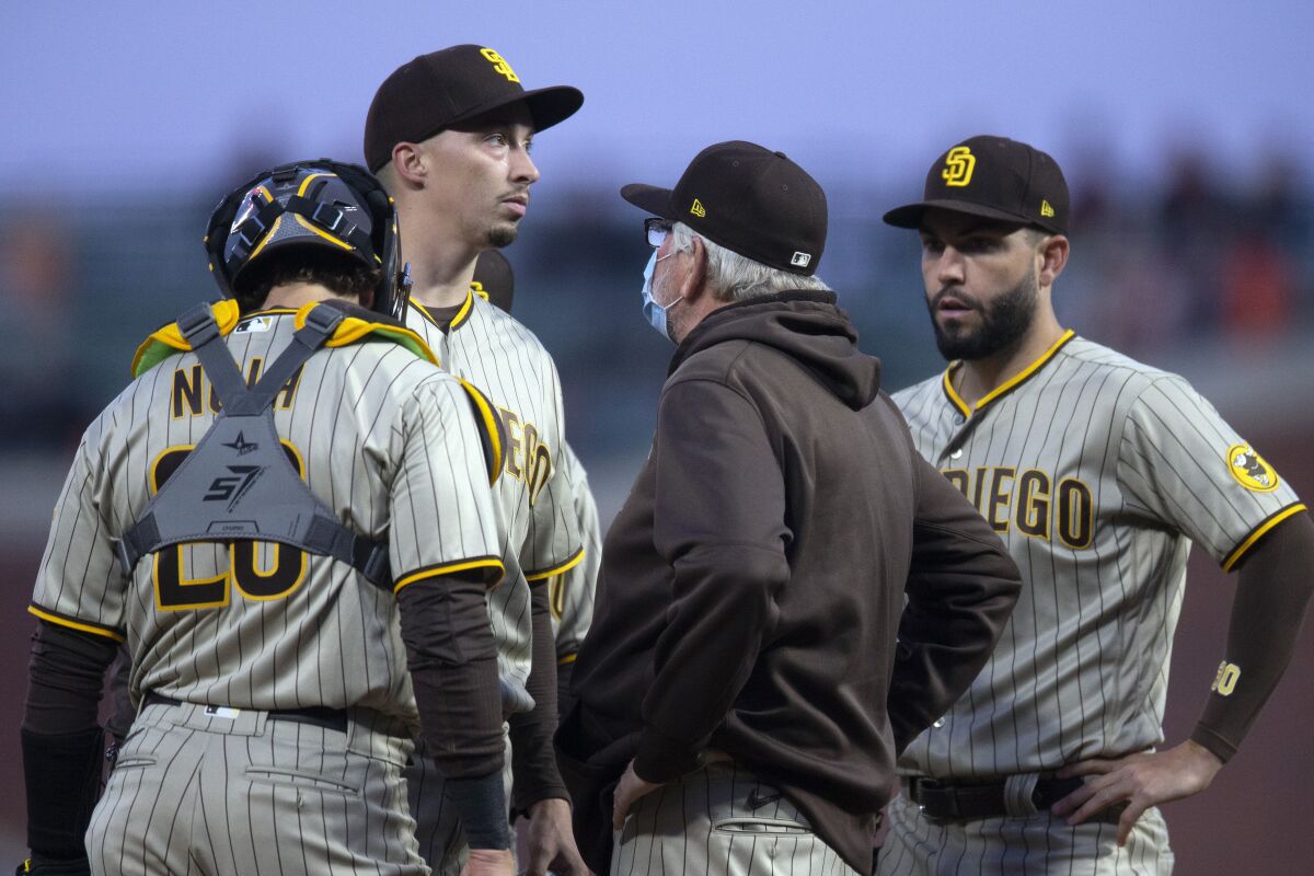 Padres starting pitcher Blake Snell, second from left, gets a visit from pitching coach Larry Rothschild