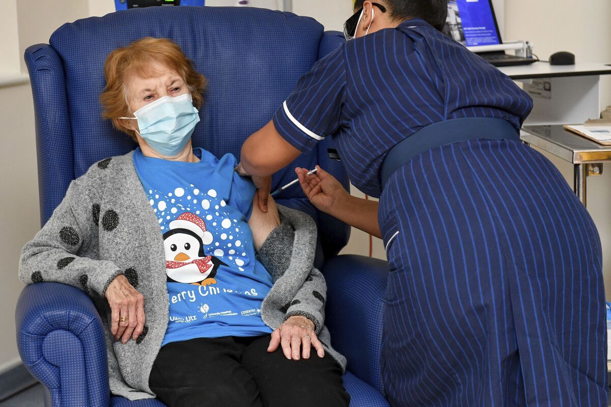 90 year old Margaret Keenan, the first patient in the UK to receive the Pfizer-BioNTech COVID-19 vaccine, administered by nurse May Parsons at University Hospital, Coventry, England, Tuesday Dec. 8, 2020. The United Kingdom, one of the countries hardest hit by the coronavirus, is beginning its vaccination campaign, a key step toward eventually ending the pandemic. (Jacob King/Pool via AP)