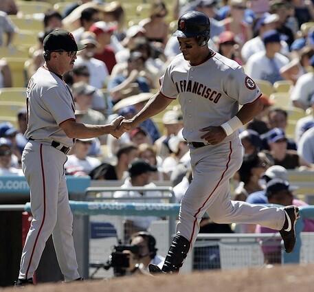 San Francisco Giants' Moises Alou, right, is congratulated by third base coach Gene Glynn after hitting a home run off Los Angeles Dodgers pitcher Joe Beimel.