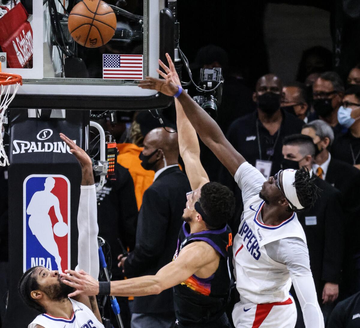 Clippers guard Reggie Jackson, right, blocks a shot by Suns guard Devin Booker during Game 5 on Monday night in Phoenix.