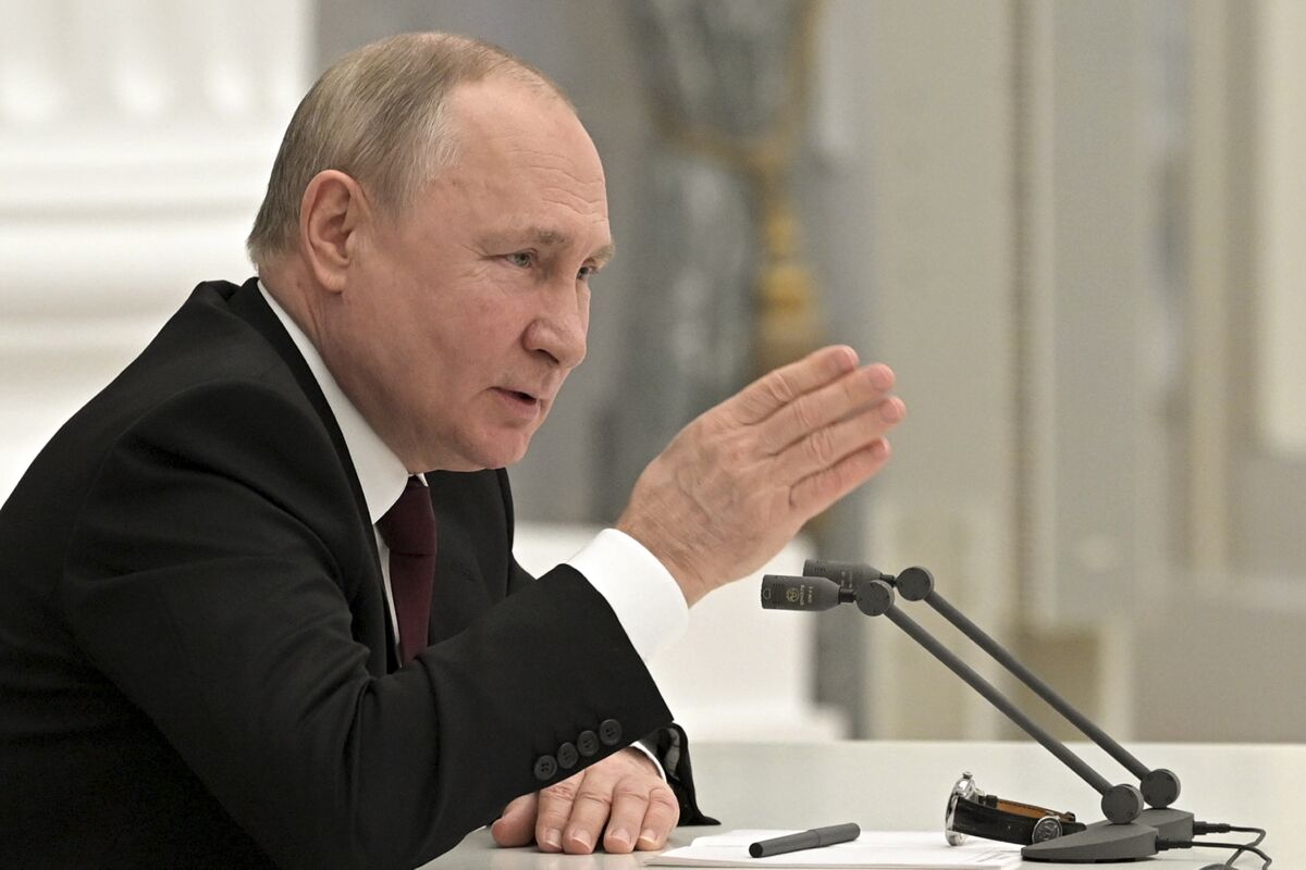 Vladimir Putin speaks at a table at the Kremlin