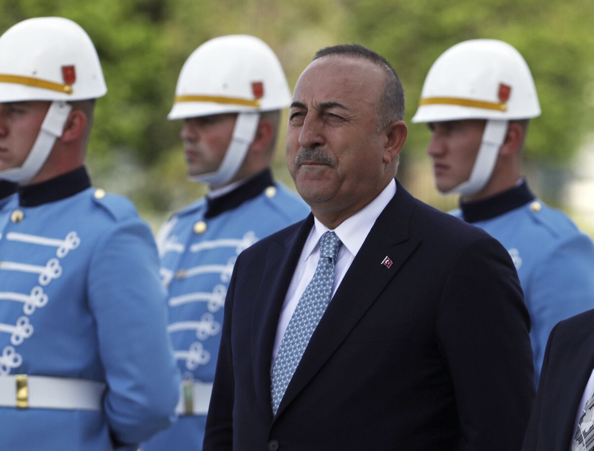 Turkish Foreign Minister Mevlut Cavusoglu stands with a military honour guard, in Ankara, Turkey, Wednesday, June 1, 2022. Cavusoglu sent a letter to the U.N. formally requesting that his country be referred to as "Türkiye," the state-run news agency reported. The move is seen as part of a push by Ankara to rebrand the country and dissociate its name from the bird, turkey, and some negative connotations that are associated with it. Anadolu Agency said Stephane Dujarric, spokesman to U.N. Secretary General, confirmed late on Wednesday that the name change had become effective "from the moment" the letter was received. (AP Photo/Burhan Ozbilici)