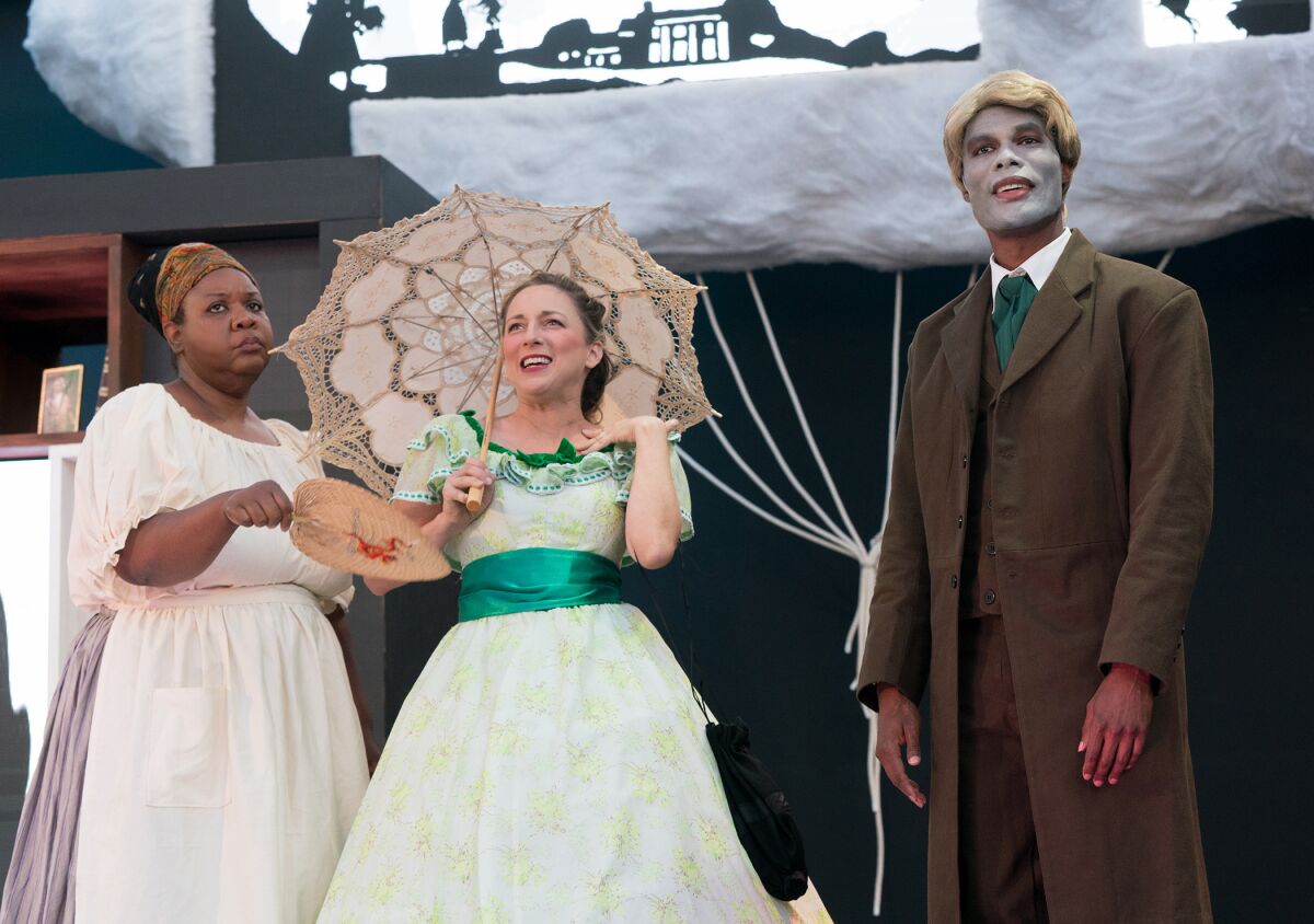 Two women and a man in period costume stand on an outdoor stage.