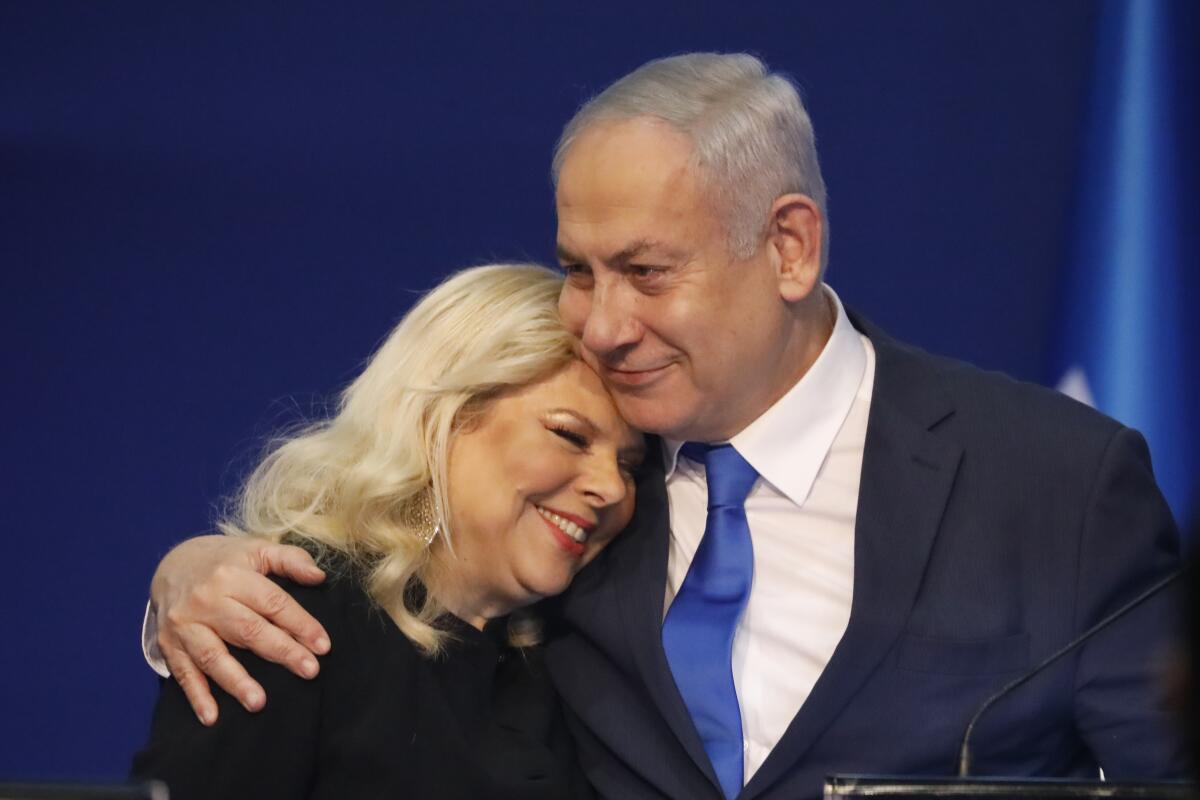 Prime Minister Benjamin Netanyahu hugs wife Sara after exit poll results in Tel Aviv.