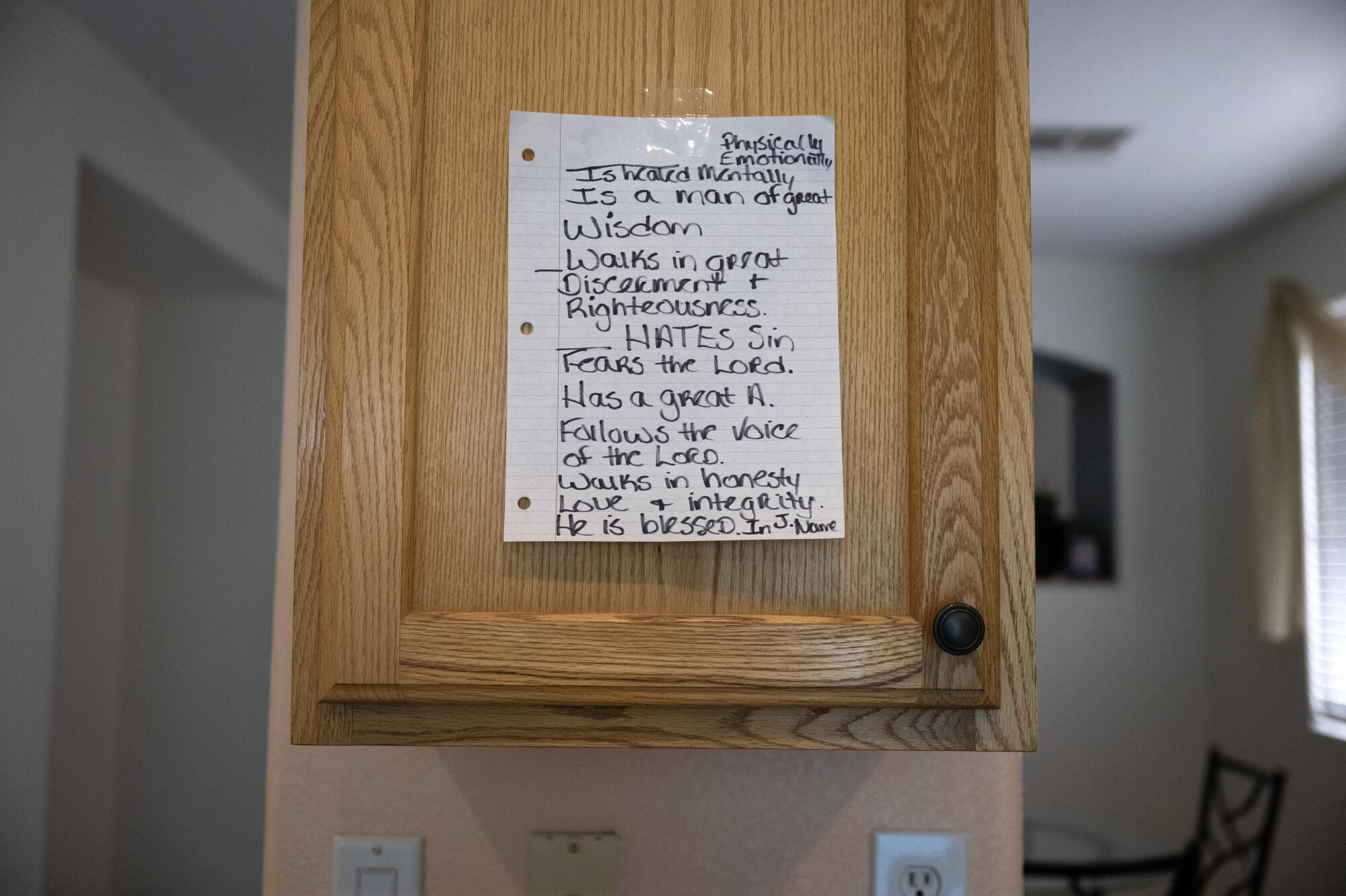  A handwritten note on lined paper is posted to a cupboard.
