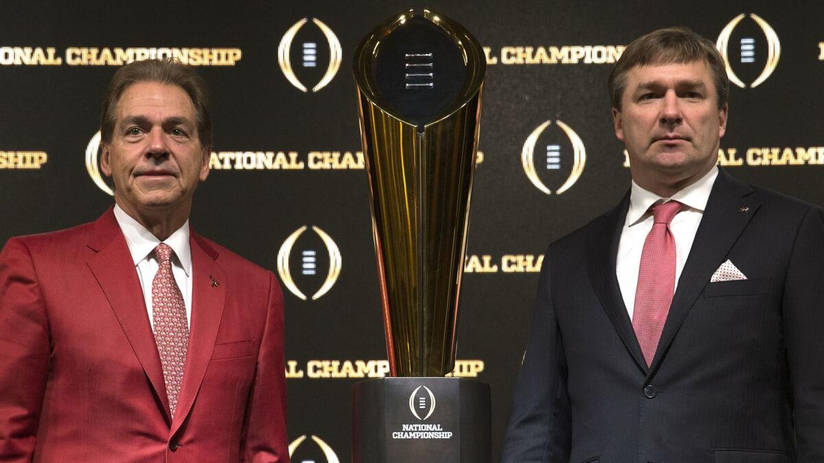 Alabama coach Nick Saban, left, and Georgia coach Kirby Smart stand with the College Football Playoff national championship trophy after a Jan. 7 news conference in Atlanta.