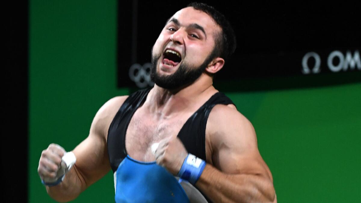 Kazakhstan's Nijat Rahimov celebrates after he won the men's 77-kilogram weightlifting competition on Wednesday.