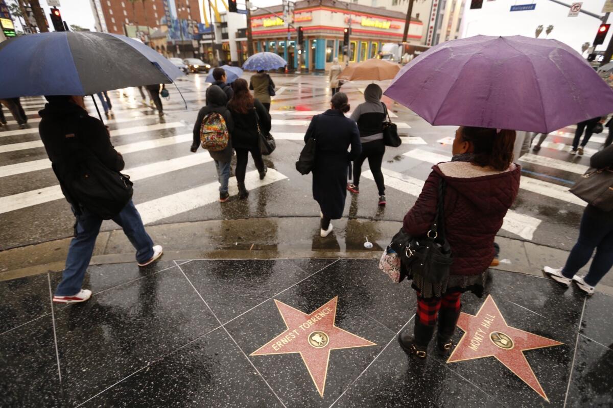 Umbrellas and rain coats are the fashion at Hollywood and Highland as scattered showers and strong winds continued to sweep over Los Angeles County on Thursday morning.