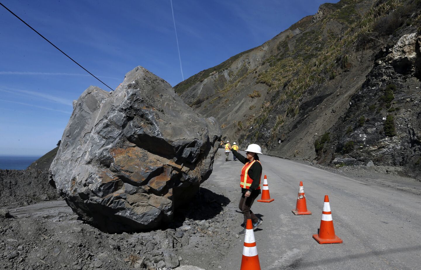 Caltrans spokeswoman Susana Cruz gets an up-close view of a bolder that came down on Highway One north of Ragged Point.