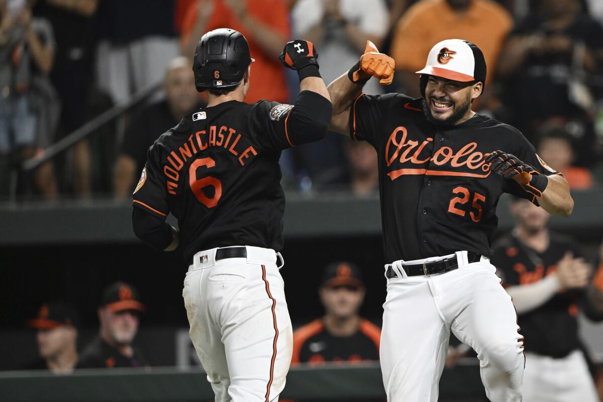 Baltimore Orioles' Anthony Santander, right, and Ryan Mountcastle celebrate Mountcastle's home run against the Boston Red Sox during the fourth inning of a baseball game Friday, Aug. 19, 2022, in Baltimore. Santander also homered in the game. (AP Photo/Gail Burton)