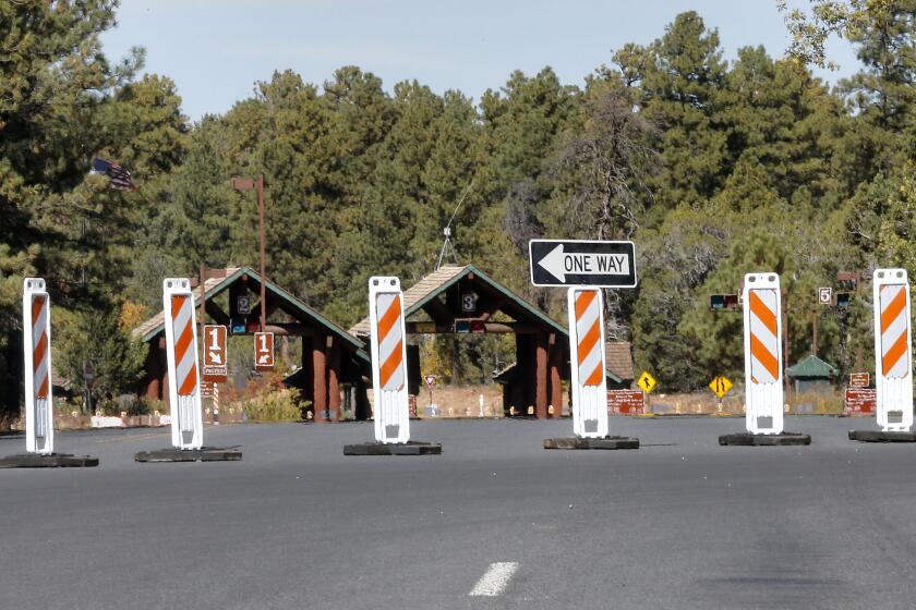 FILE - The Grand Canyon National Park entrance is blocked off, in Tusayan, Ariz., Oct. 8, 2013, because of a partial government shutdown. Arizona's Grand Canyon National Park and all five national parks in Utah will remain open if the U.S. government shuts down, Sunday, Oct. 1, 2023. Arizona Gov. Katie Hobbs and Utah Gov. Spencer Cox say that the parks are important destinations and local communities depend on dollars from visitors. (AP Photo/Matt York, File)