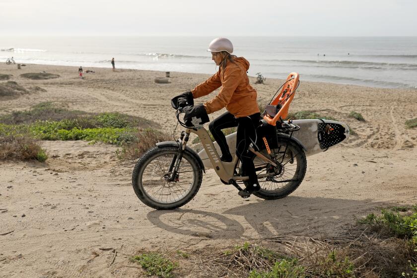 SAN CLEMENTE, CA - JANUARY 12: A surfer with an electric bike (e-bike) at Trestles Thursday, Jan. 12, 2023 in San Clemente, CA. Orange County cities attempting to regulate electric bikes (e-bikes) with varying degrees of success. (Gary Coronado / Los Angeles Times)