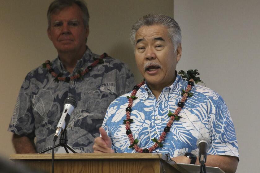 FILE - In this Tuesday, March 3, 2020, file photo, Hawaii Gov. David Ige speaks to reporters at the state Department of Health's laboratory in Pearl City, Hawaii. Ige said Monday, July 13, 2020, he will wait another month to waive a 14-day quarantine requirement for out-of-state travelers who test negative for COVID-19, citing increasing virus cases in Hawaii, "uncontrolled" outbreaks in several U.S. mainland states and a shortage of testing supplies. (AP Photo/Audrey McAvoy, File)