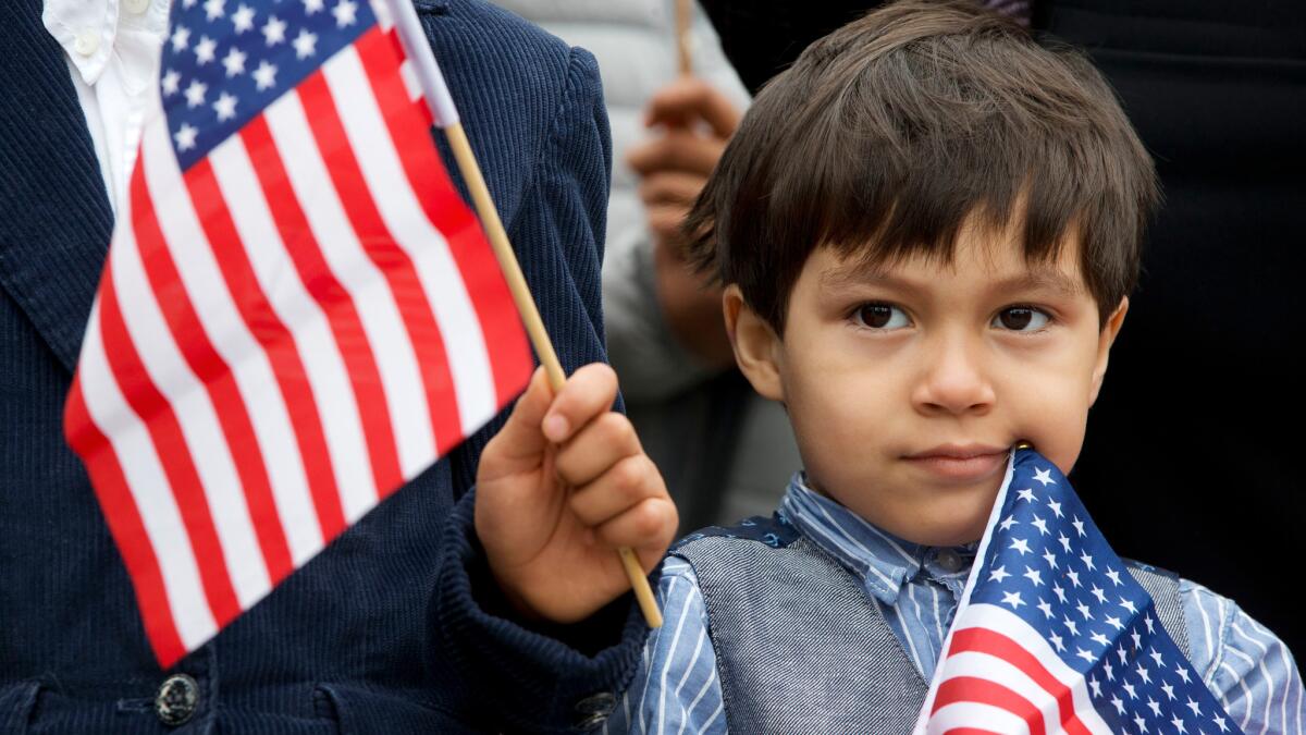 Iker Velasquez, 4, who came from Honduras with his parents, holds a U.S. flag in Washington on May 18.