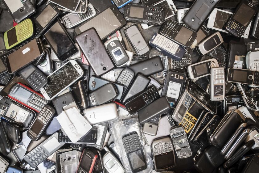 In this photo taken on July 13, 2018, old mobile phones fill a bin at the Out Of Use company warehouse in Beringen, Belgium. The world's mountain of discarded flat-screen TVs, cellphones and other electronic goods grew to a record high last year, according to an annual report released Thursday. (AP Photo/Geert Vanden Wijngaert)