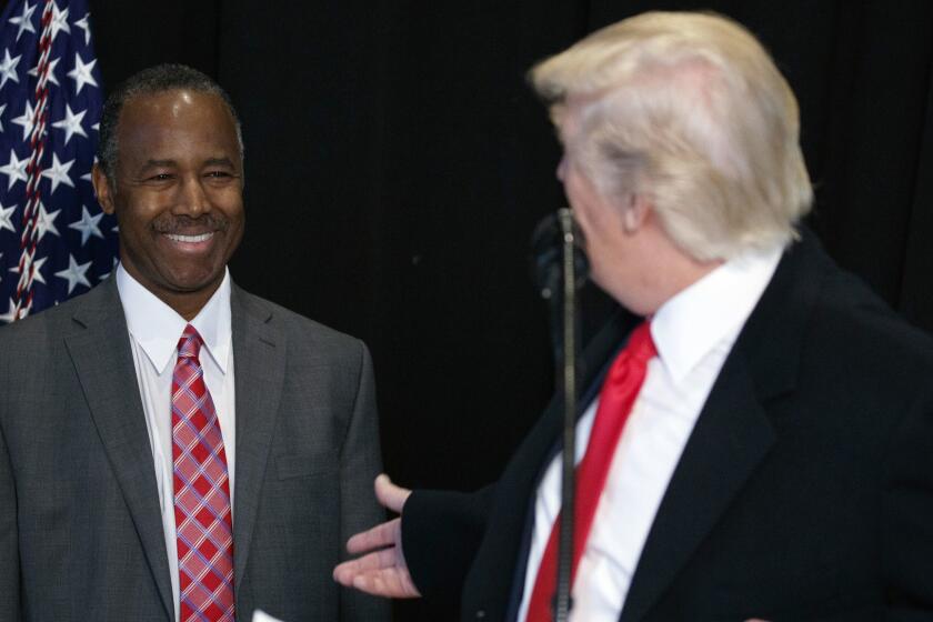 FILE - In this Feb. 21, 2017, file photo, then-Housing and Urban Development Secretary-designate Dr. Ben Carson, listens as President Donald Trump speaks after touring the National Museum of African American History and Culture in Washington. Carsonâs story of growing up in a single-parent household and climbing out of poverty to become a world-renowned surgeon was once ubiquitous in Baltimore, where Carson made his name. But his role in the Trump Administration has added a complicated epilogue, leaving many who admired him feeling betrayed, unable to separate him from the politics of a president widely rejected by African Americans in Baltimore. (AP Photo/Evan Vucci, File)