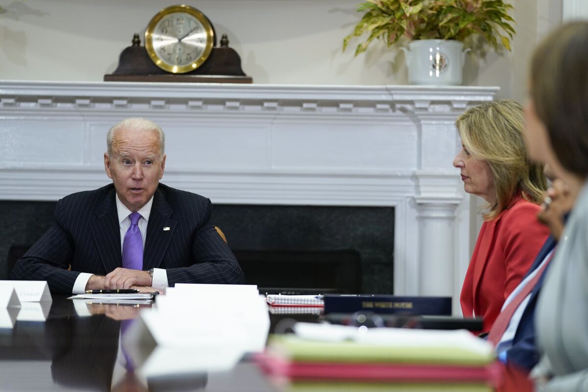 President Biden sits at a table with other people
