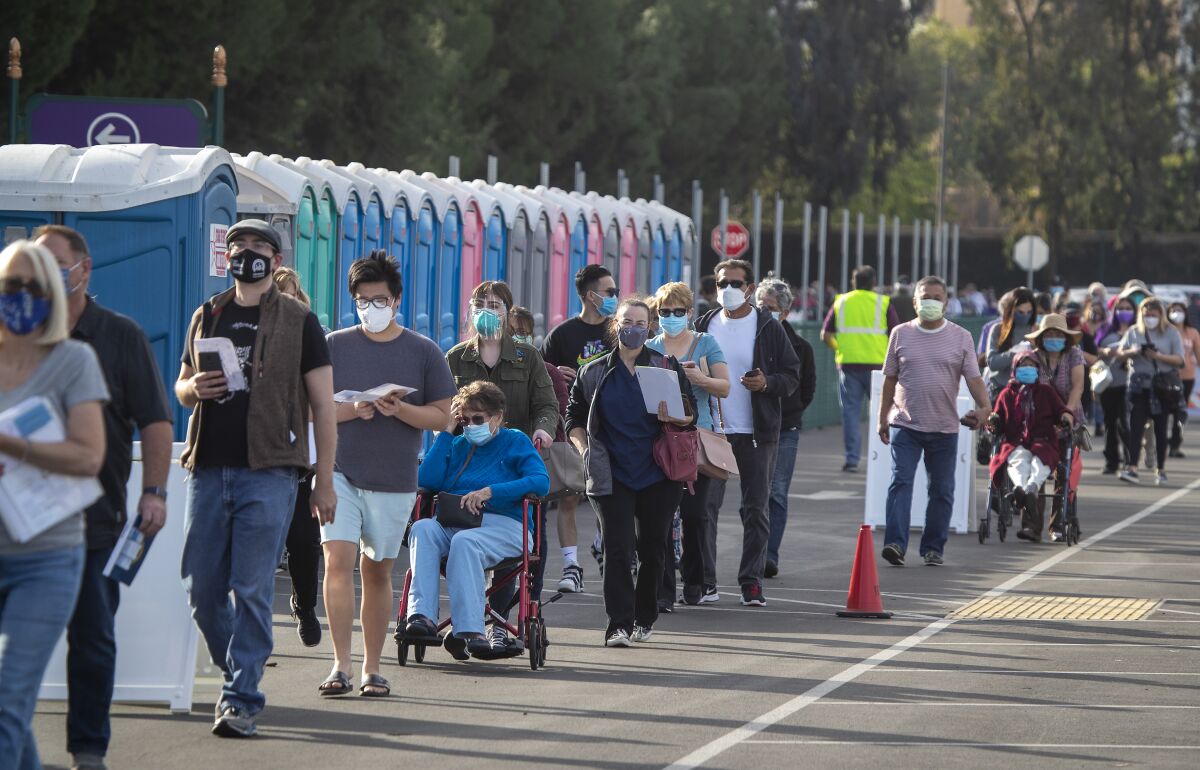 Healthcare workers wait in line at a vaccination site in the parking lot at the Disneyland in Anaheim