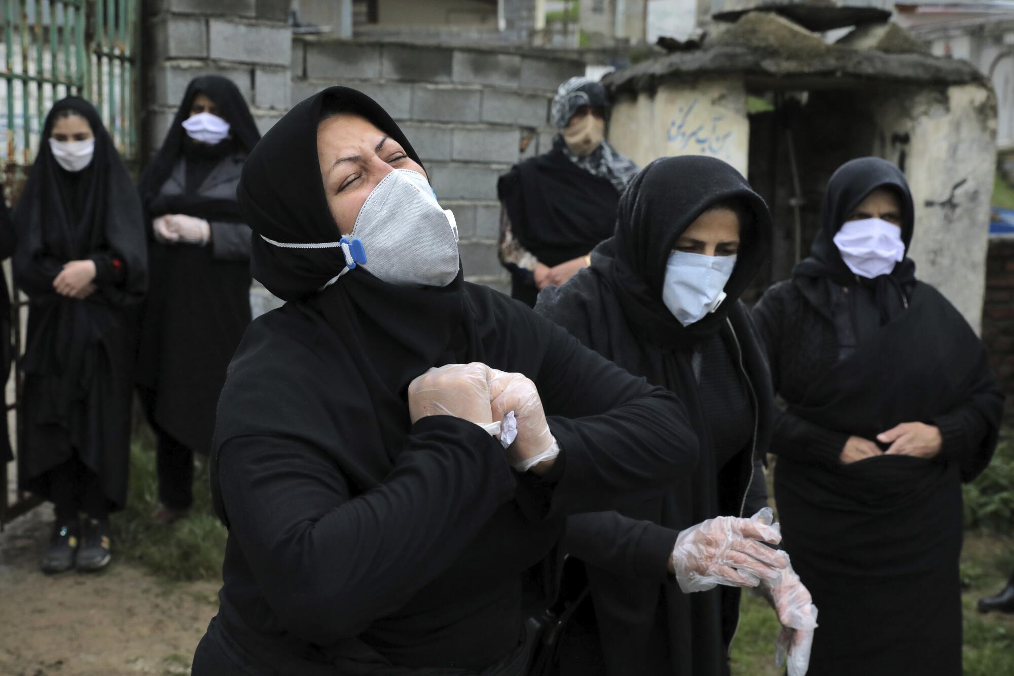 Relatives mourn at the gate of a cemetery in northern Iran.